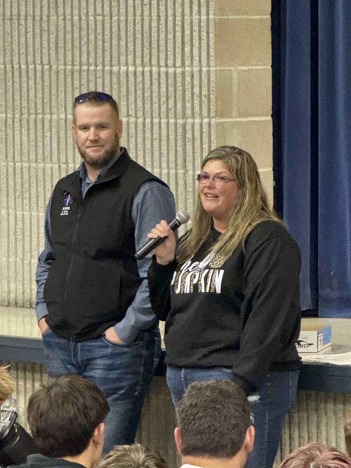 shawn gott and jill payne talking on mic at an assembly