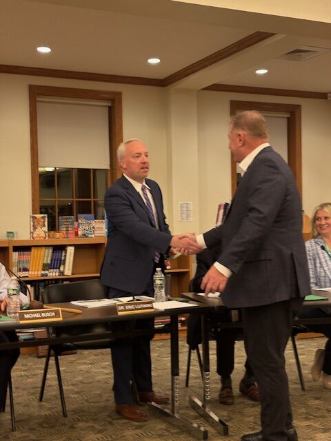 Masonic Lodge member, Tony Burton shaking hands with Dr. Lutinski. 