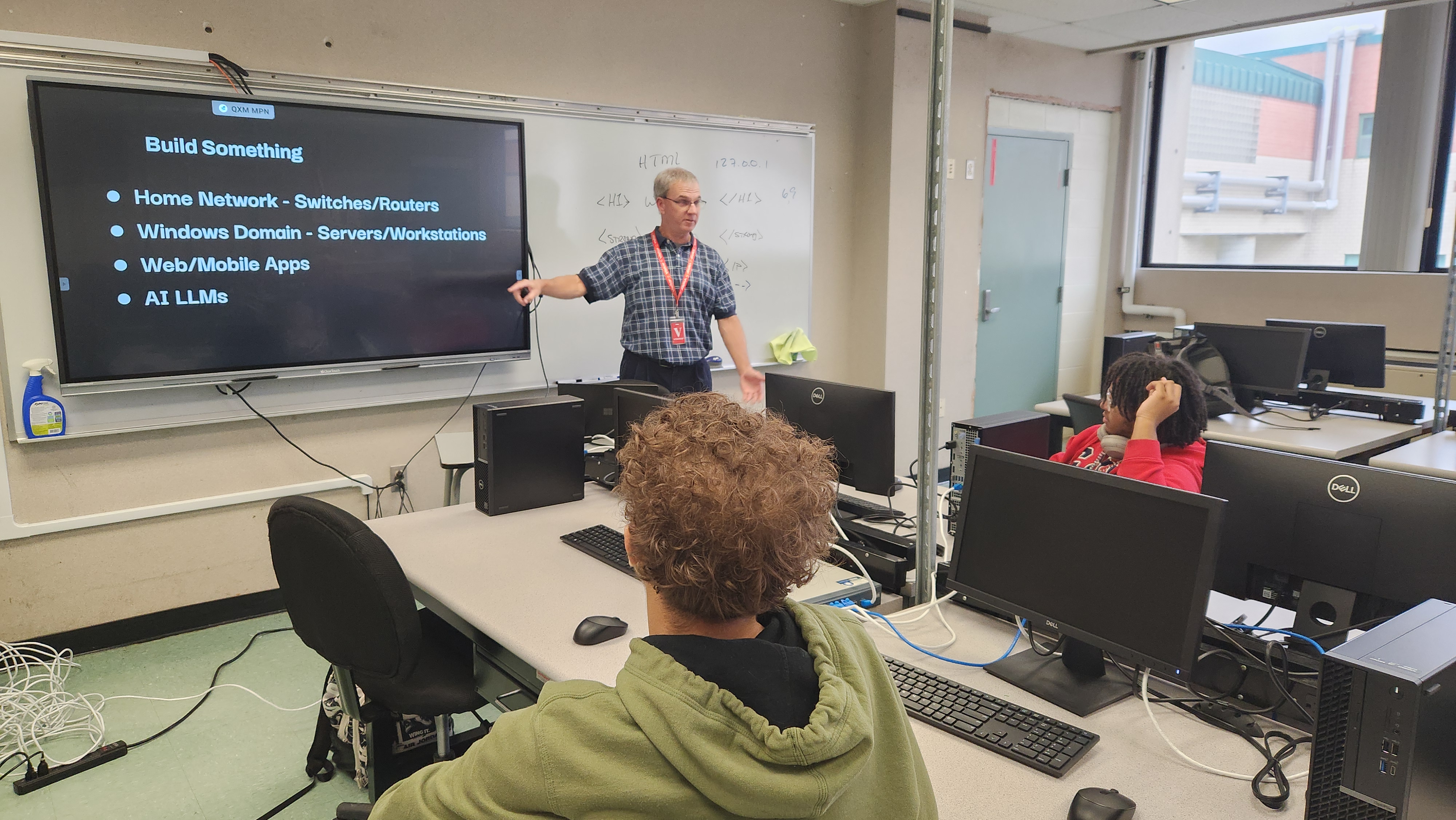 Patrick Laverty points to a screen with 'Build Something' and related topics in a computer lab.