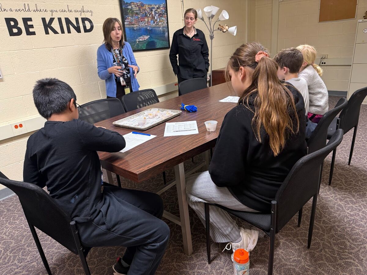 A group of students and teachers participate in a classroom activity.