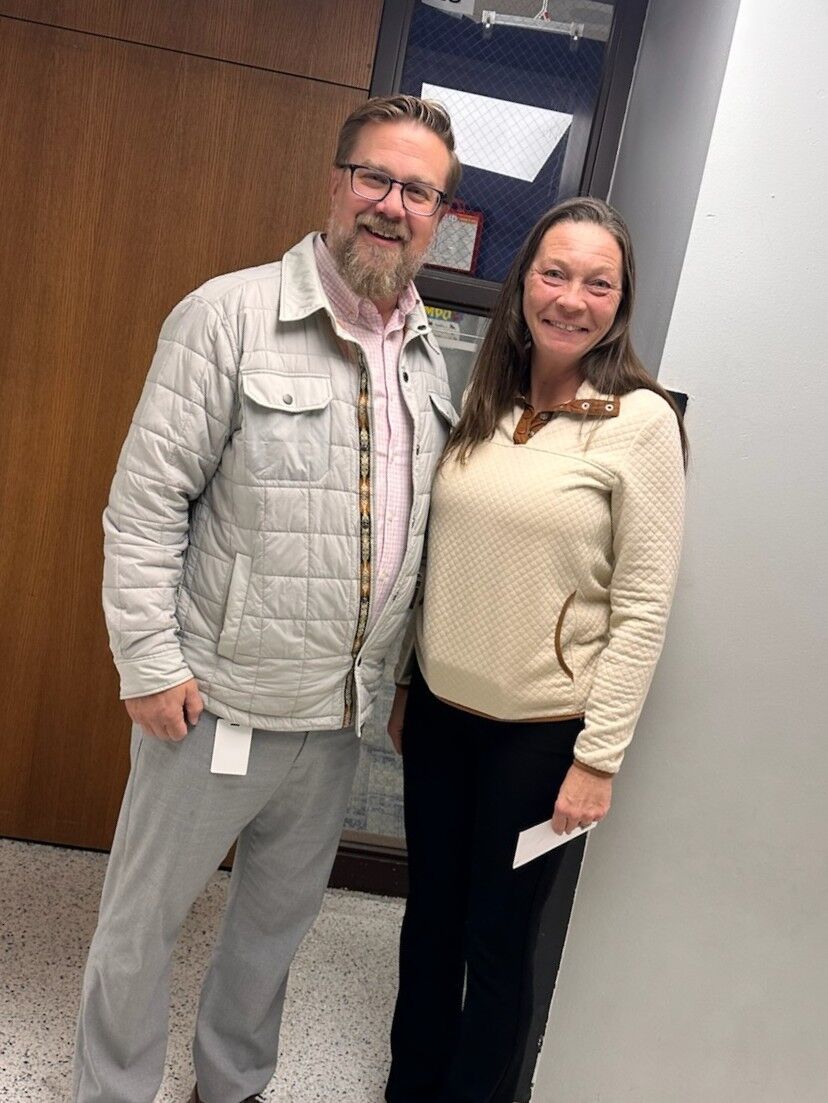 Dr. Robinson and Ms. Amber pose for a photo in front of a classroom