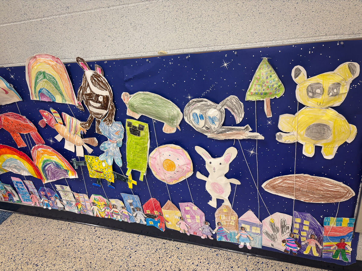 A colorful display of children's artwork on a blue background.