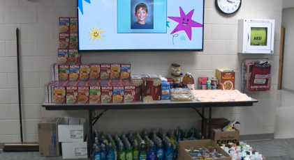 A table displays various food items and supplies for a donation.
