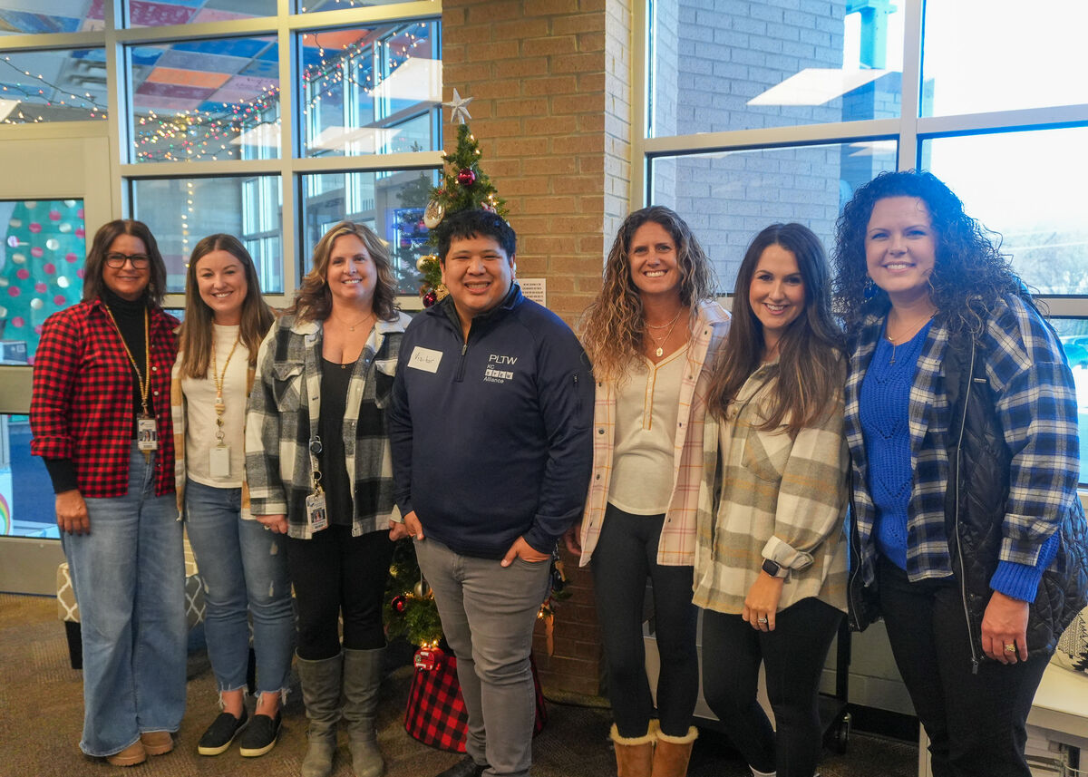 A photo of a group of staff smiling and standing in the office. 