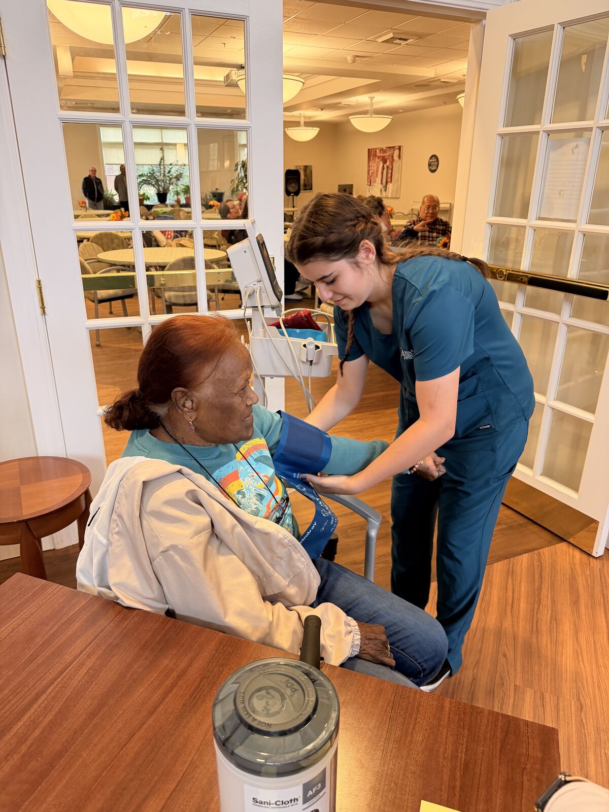 A healthcare worker takes a patient's blood pressure in a care facility. Arianna Lerio Singarella