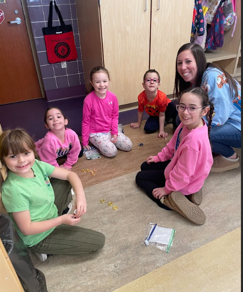 Parent sharing with K students how to play the dreidel game.