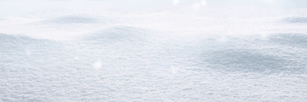 Soft, undulating snowdrifts under a bright, hazy sky.