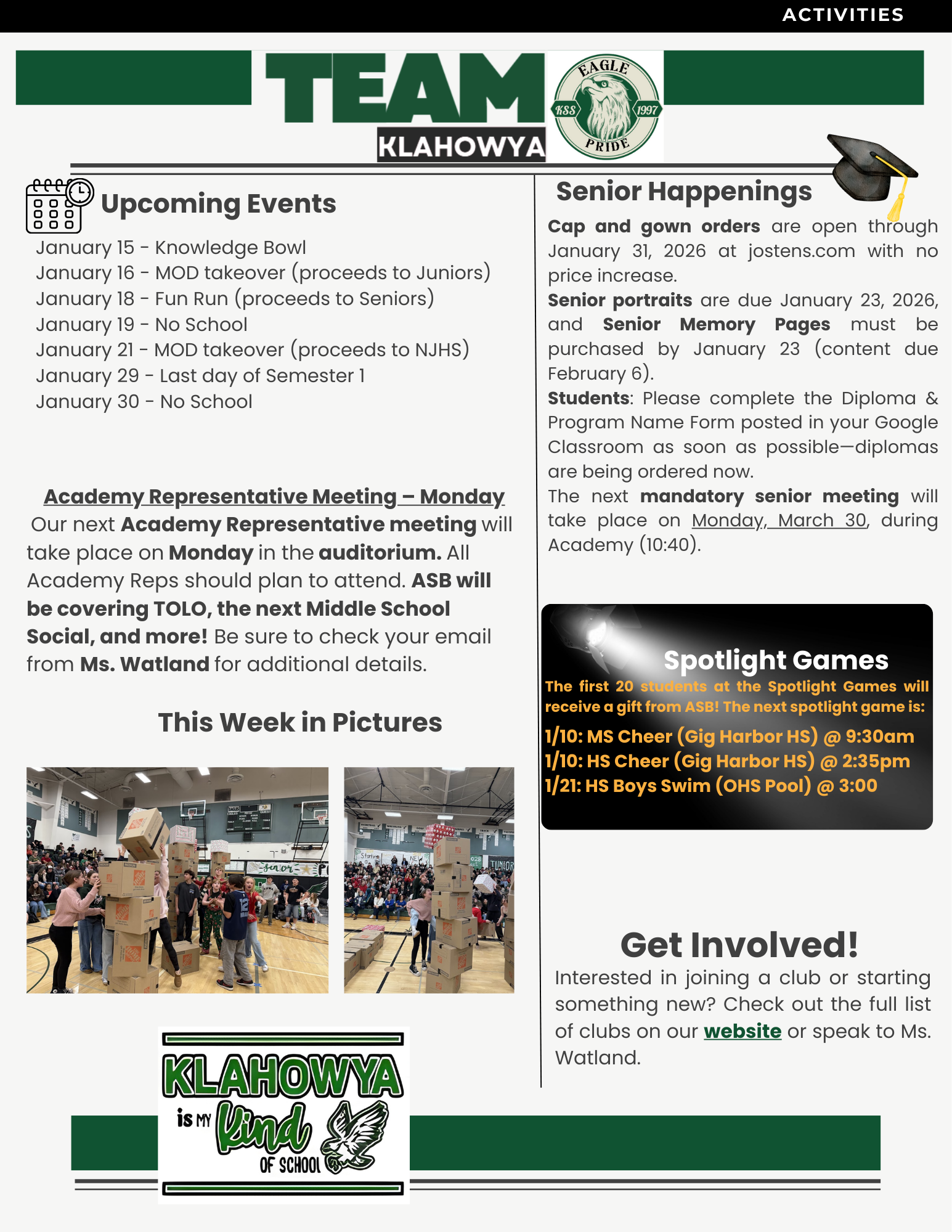 Students build tall towers out of cardboard boxes in a school gymnasium.