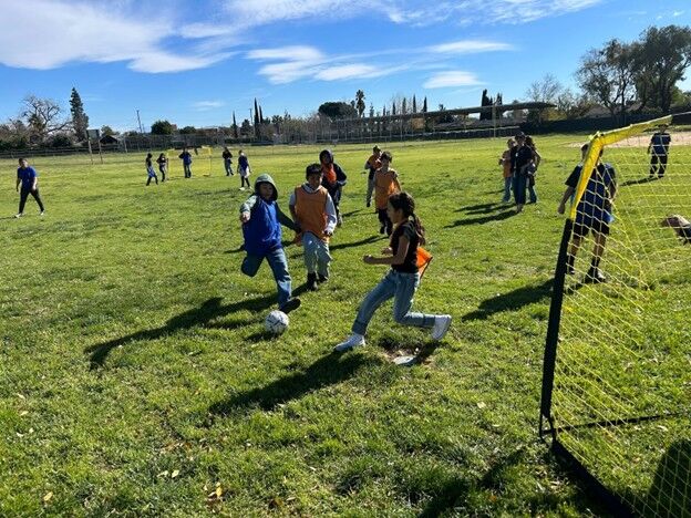 Image of students playing soccer during recess.