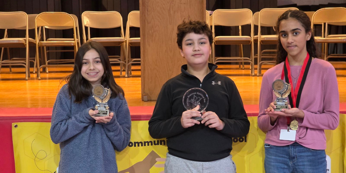A photo of three students holding trophies for their participation in the school's annual Scripp's Spelling Bee.