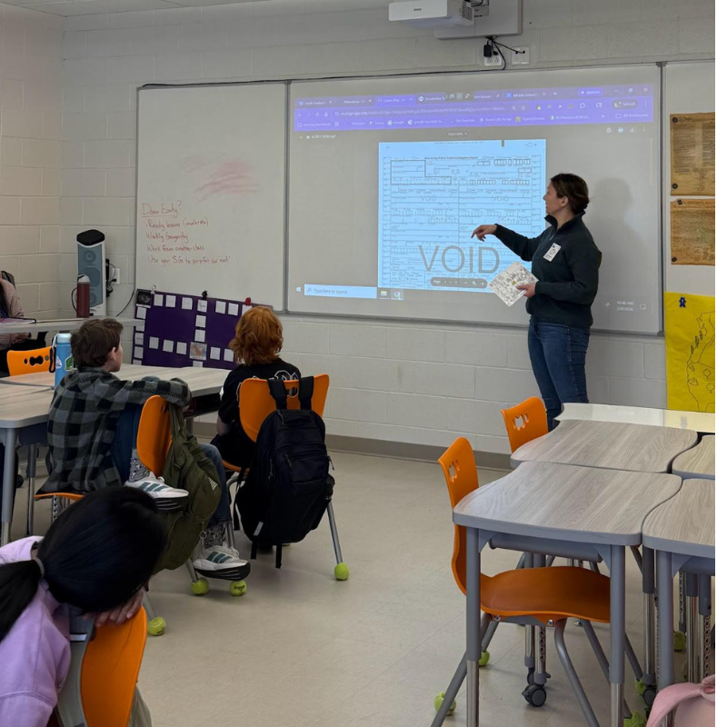 A teacher points to a projected image of a form with the word 'VOID' prominently displayed, while students watch.