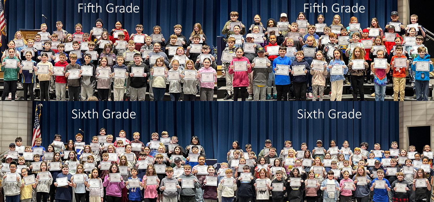 Students in Fifth Grade proudly hold certificates on stage.