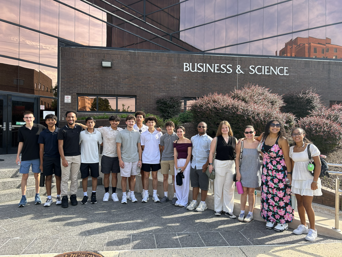 A diverse group of young people stands in front of a building labeled "BUSINESS & SCIENCE".
