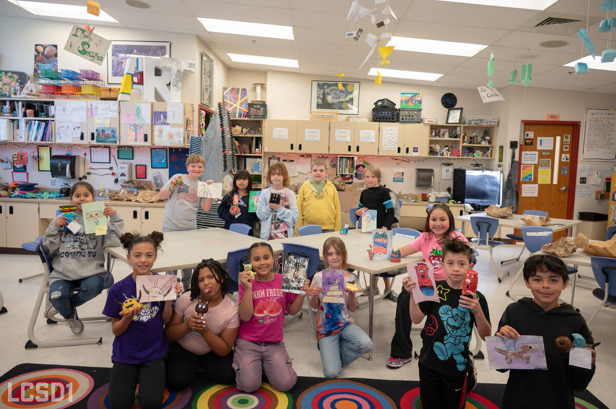 A diverse group of children proudly display their artwork and crafts in a colorful classroom.