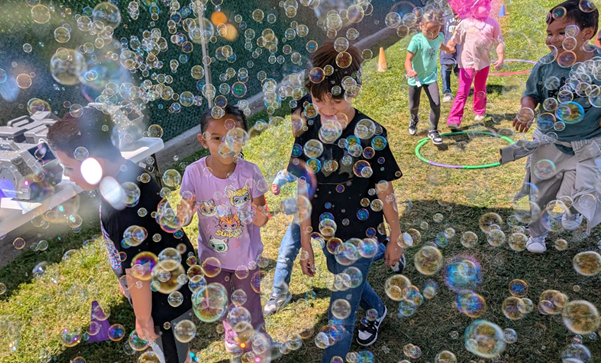 TK students smiling, enjoying the bubble run.