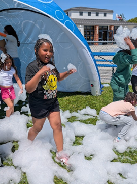 Students dashing through suds and bubbles.