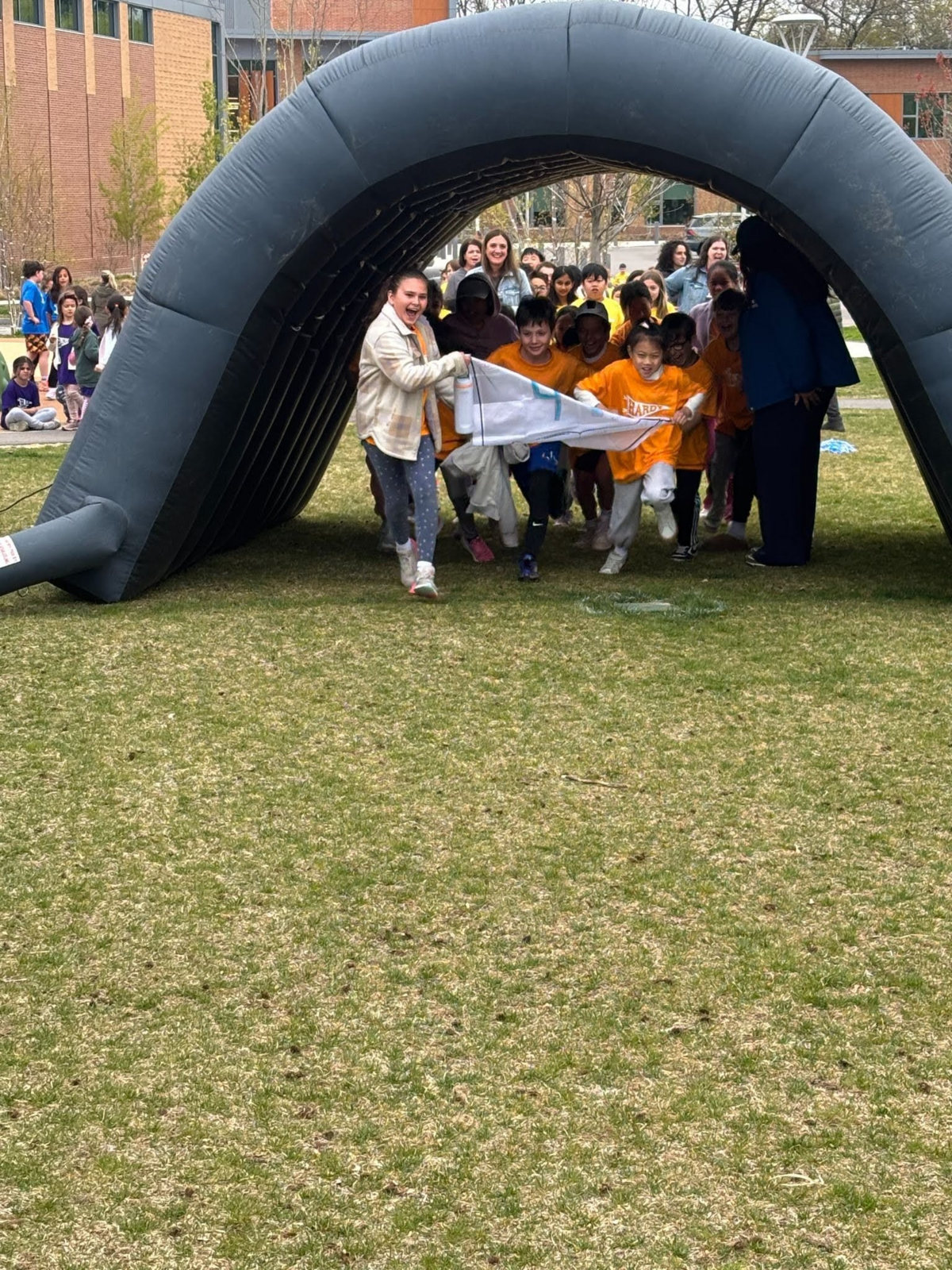 Students run through an inflatable arch at the Hardy Fun Run.