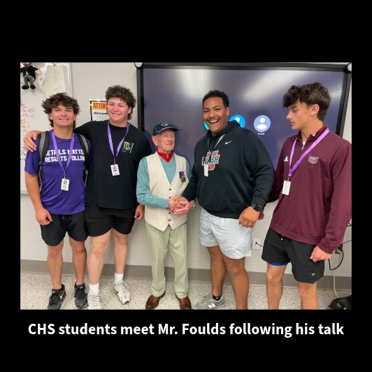 Four CHS students pose with Mr. Foulds after his presentation, shaking hands.