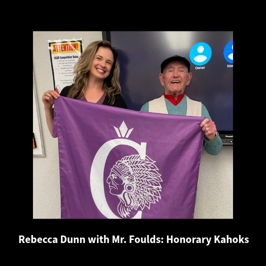 Rebecca Dunn and Mr. Foulds proudly display a purple flag with a Native American profile and a stylized 'C'.