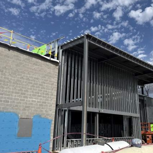 A building under construction with a steel frame and brick exterior.