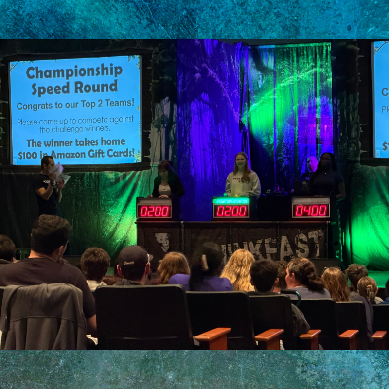 A championship speed round competition is underway with contestants at podiums and digital scoreboards displaying scores.
