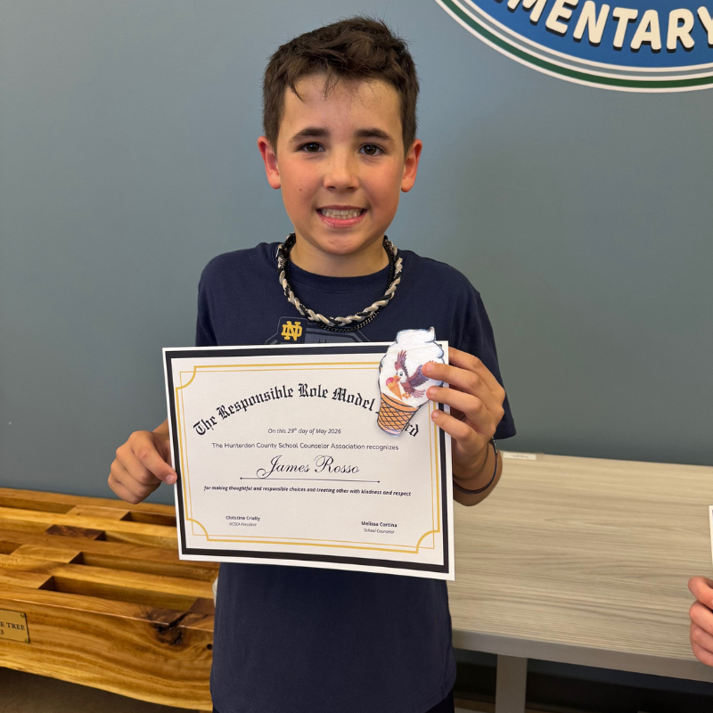 A smiling boy holds a certificate recognizing him as a "Responsible Role Model" by the Hunterdon County School Counselor Association.