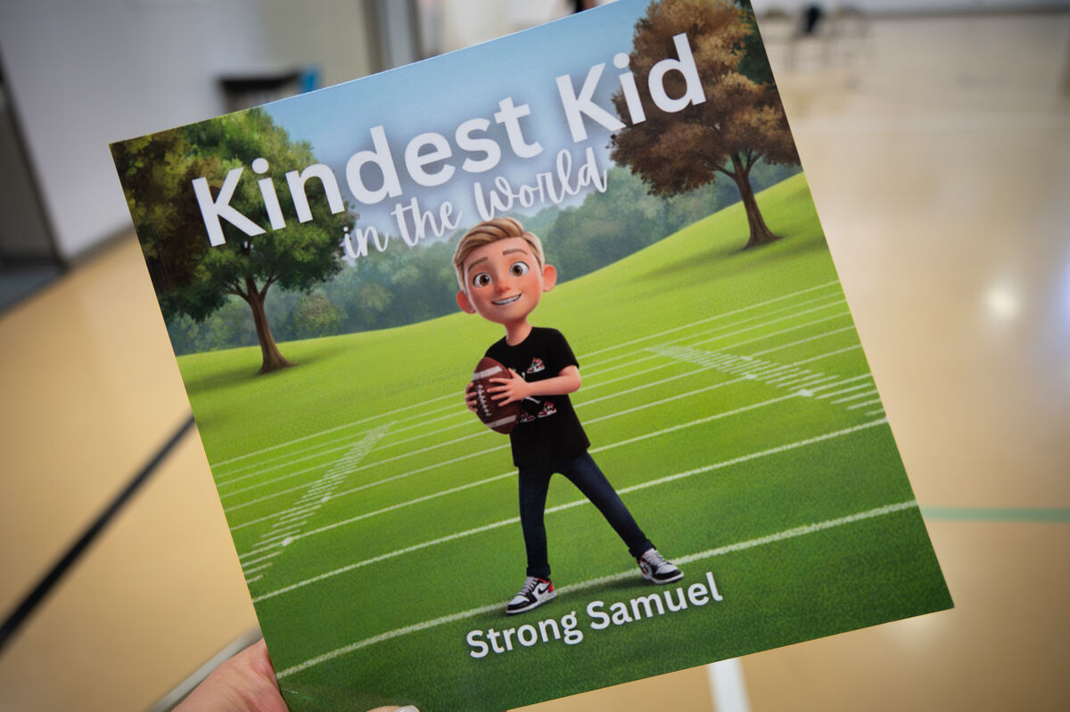 A book cover titled 'Kindest Kid in the World' features a cartoon boy holding a football on a grassy field.