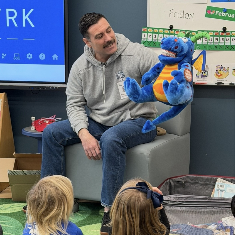 A man and a puppet give a presentation.