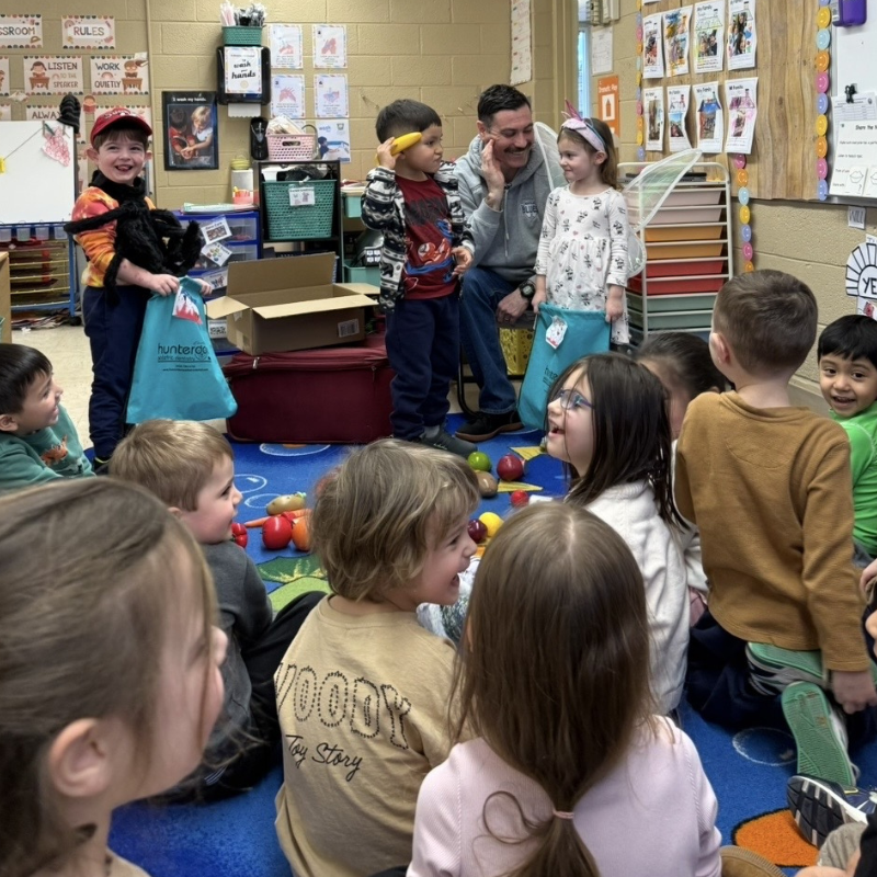 Kids gathered around to see a presentation. 