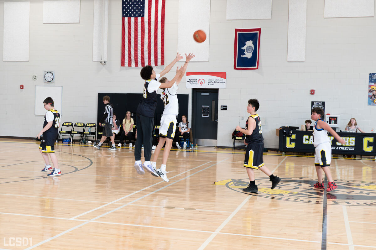 A student takes a shot during a basketball game.