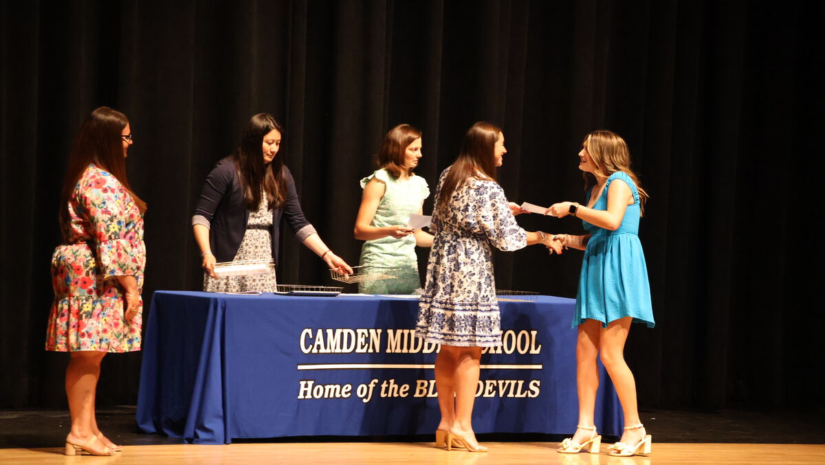 A student receives a certificate from at the eighth grade moving up ceremony.