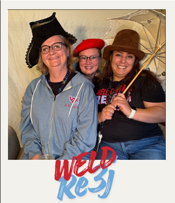 Three smiling people pose together wearing fun hats and holding a lace parasol, with the text "WELD RE-3J" at the bottom.