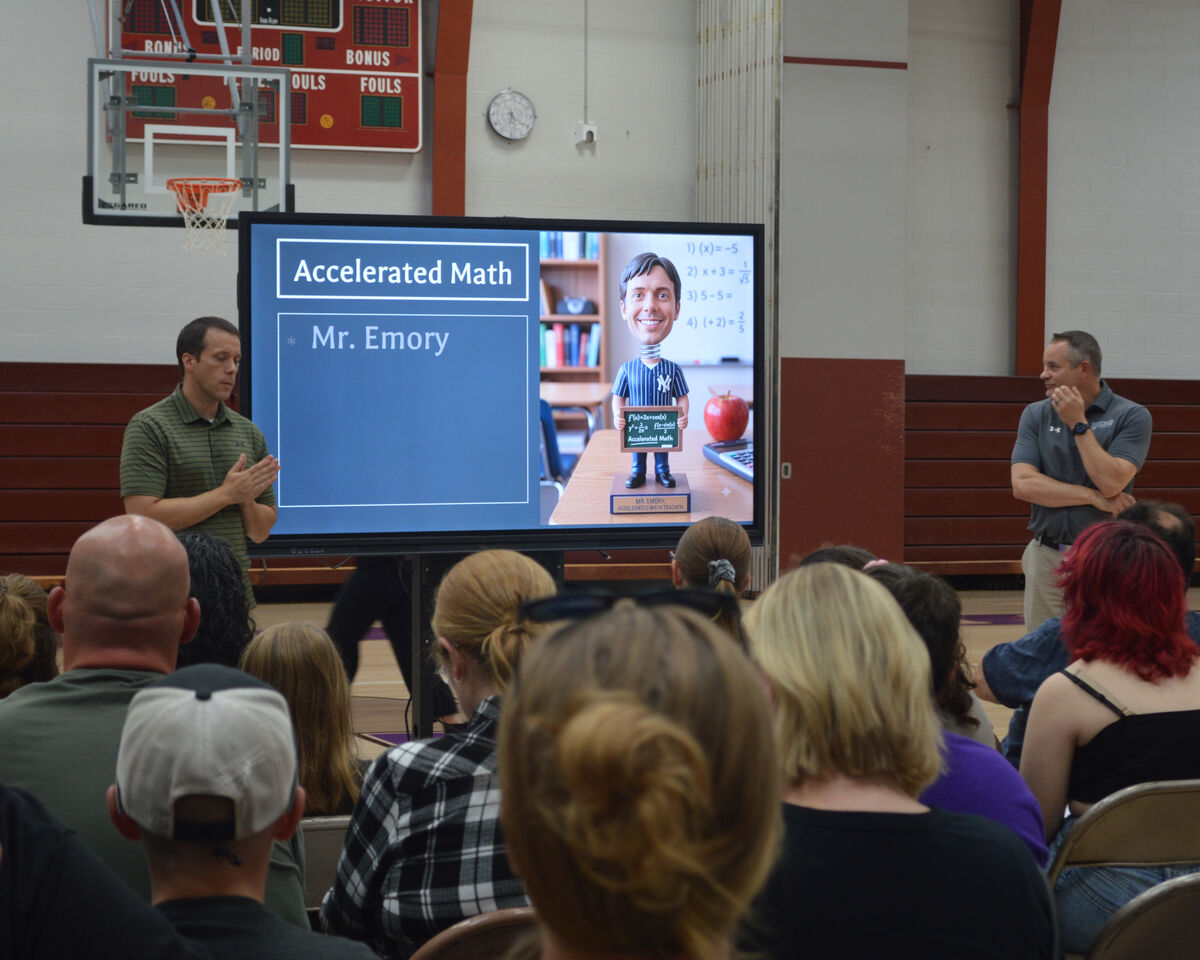 A presenter stands near a large screen displaying 'Accelerated Math' and 'Mr. Emory'.
