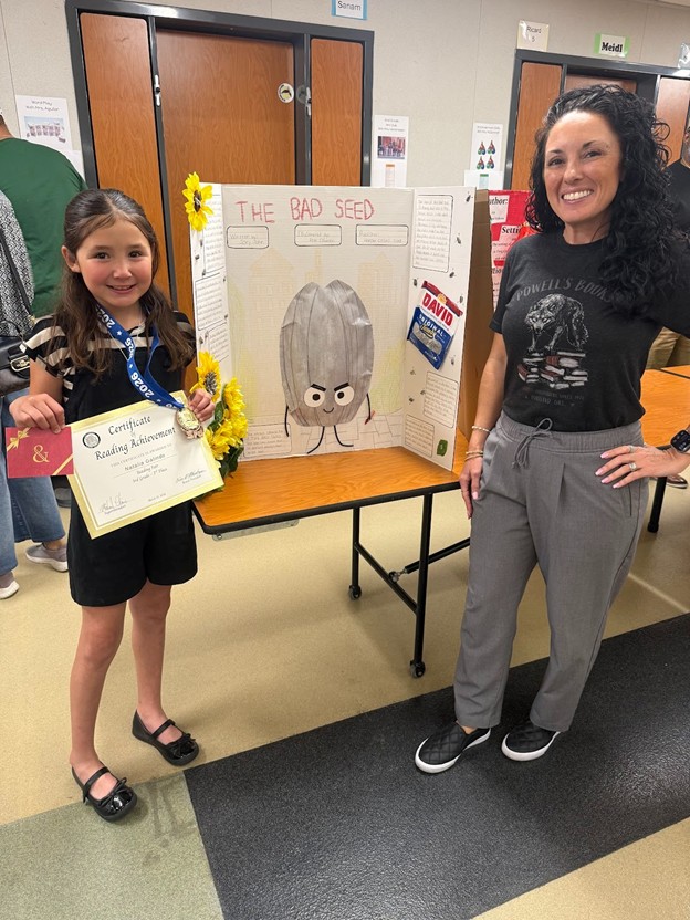 Image of Principal Arreguin with a Los Amigos Elementary School student that was recognized for their outstanding project at the District Reading Fair.