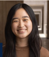  young woman with long, dark hair smiles warmly at the camera.