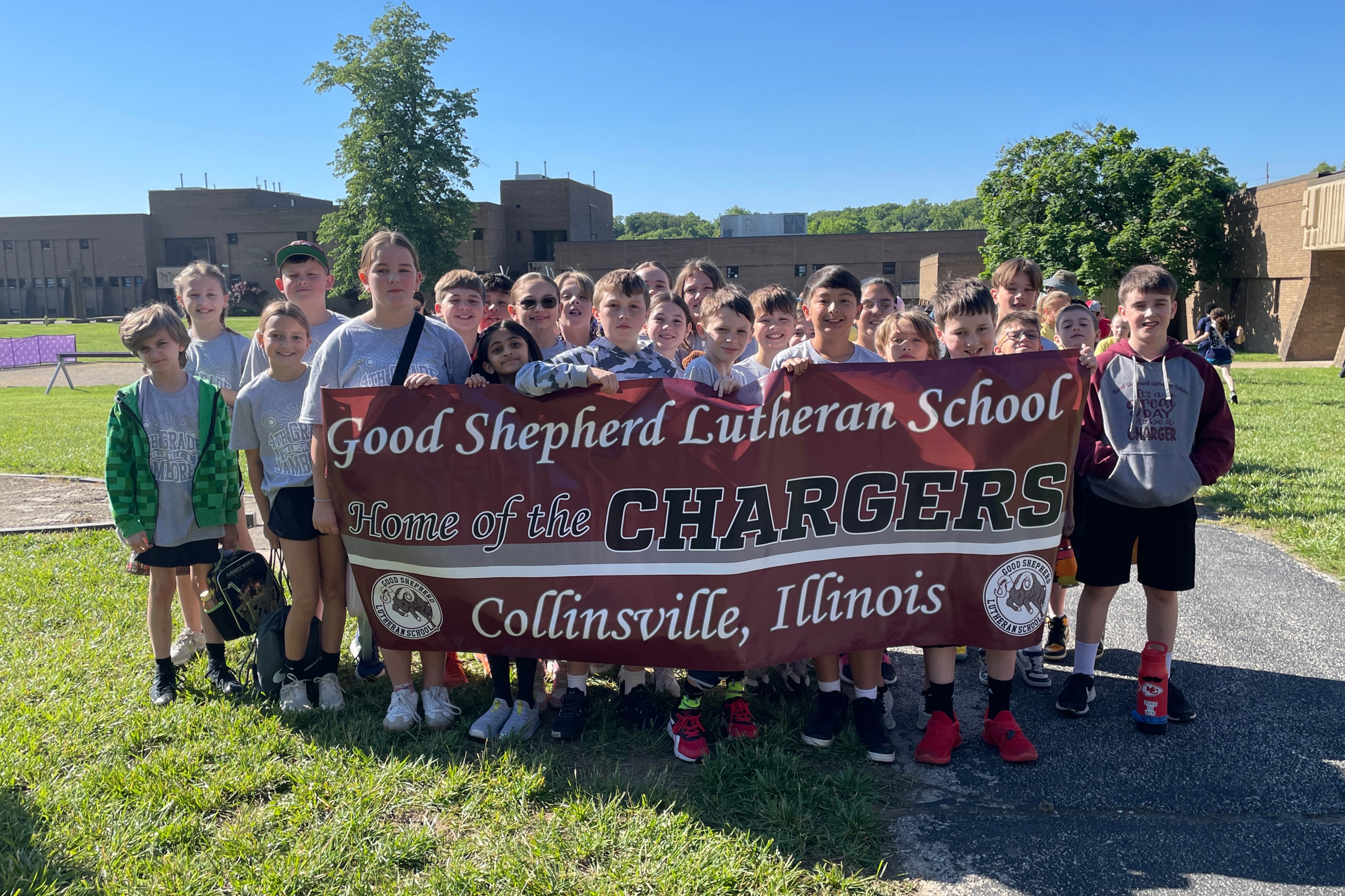 A group of students from Good Shepherd Lutheran School in Collinsville, Illinois, proudly hold a banner that reads 'Home of the CHARGERS'.
