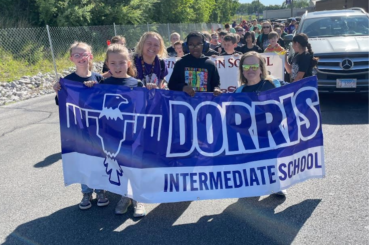 Students and staff proudly hold a banner for "DORRIS INTERMEDIATE SCHOOL" during an outdoor event.