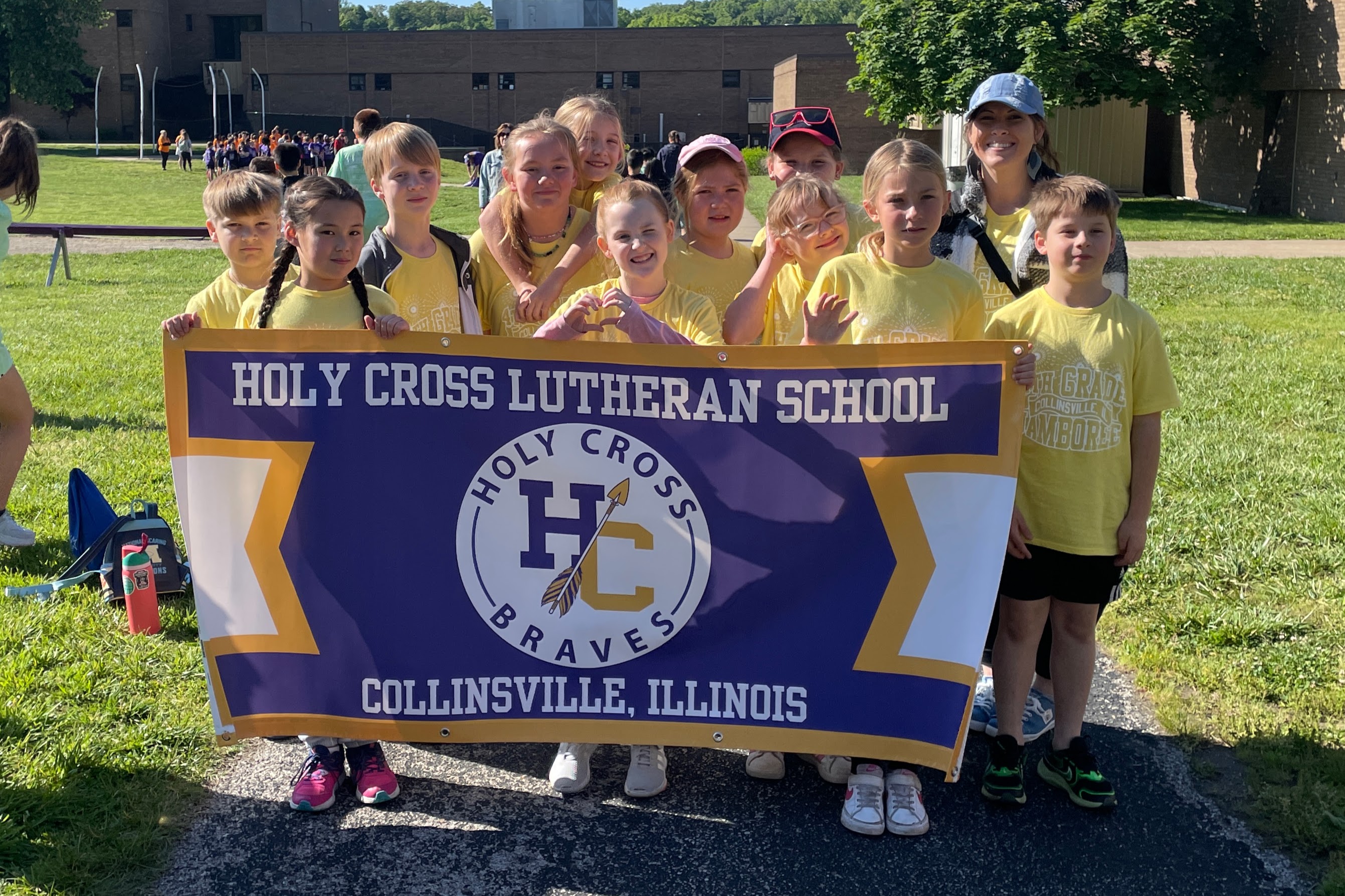 Students and a teacher from Holy Cross Lutheran School in Collinsville, Illinois, pose with their school banner.