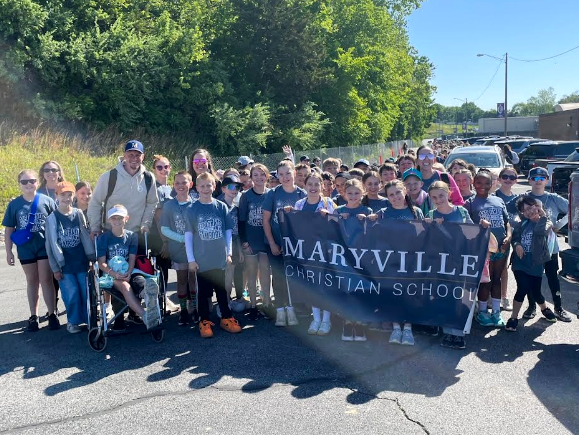 A large group of students and adults from Maryville Christian School pose for a photo, holding a banner.