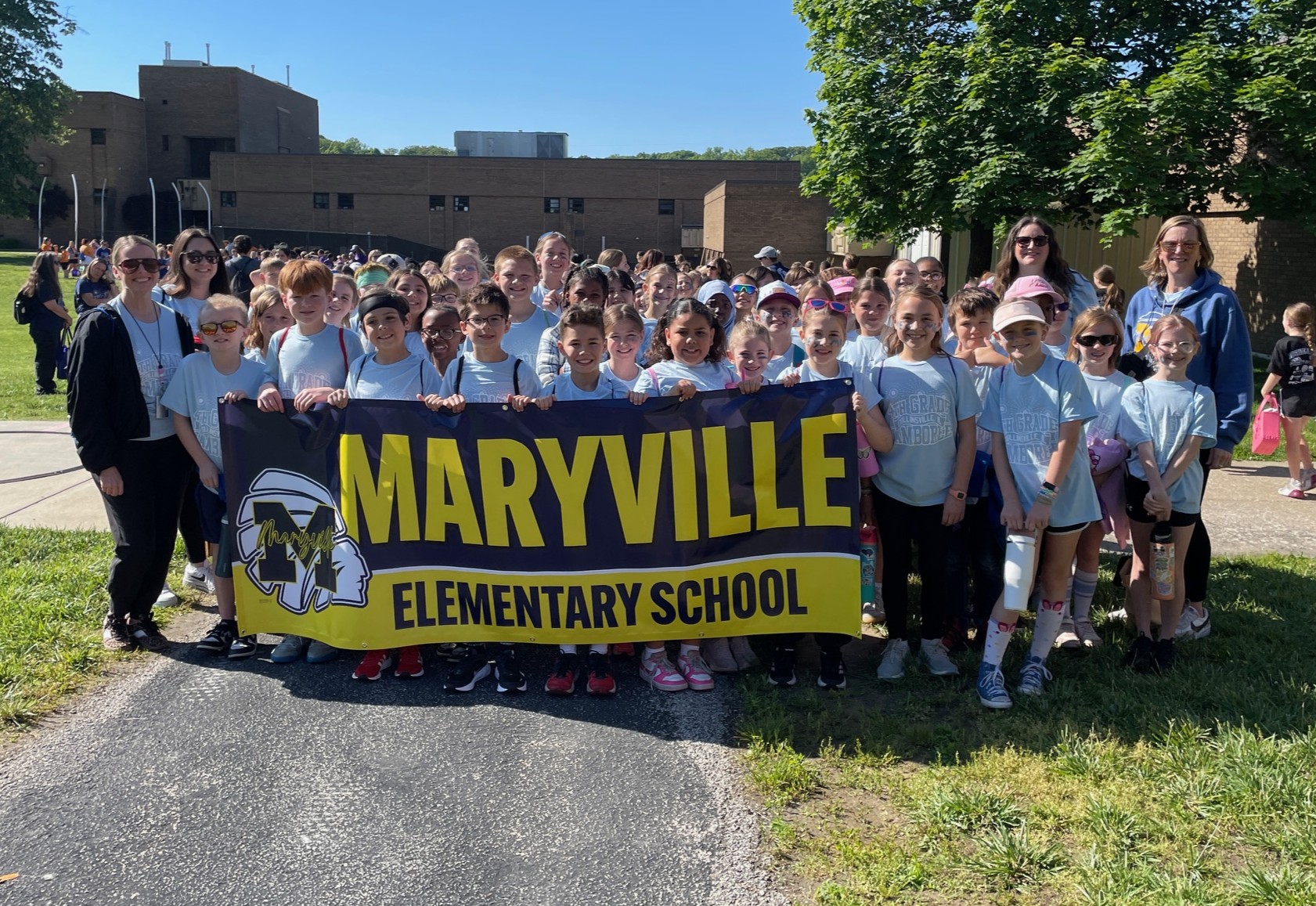 A large group of smiling elementary school students and adults hold a banner that reads 'MARYVILLE ELEMENTARY SCHOOL'.