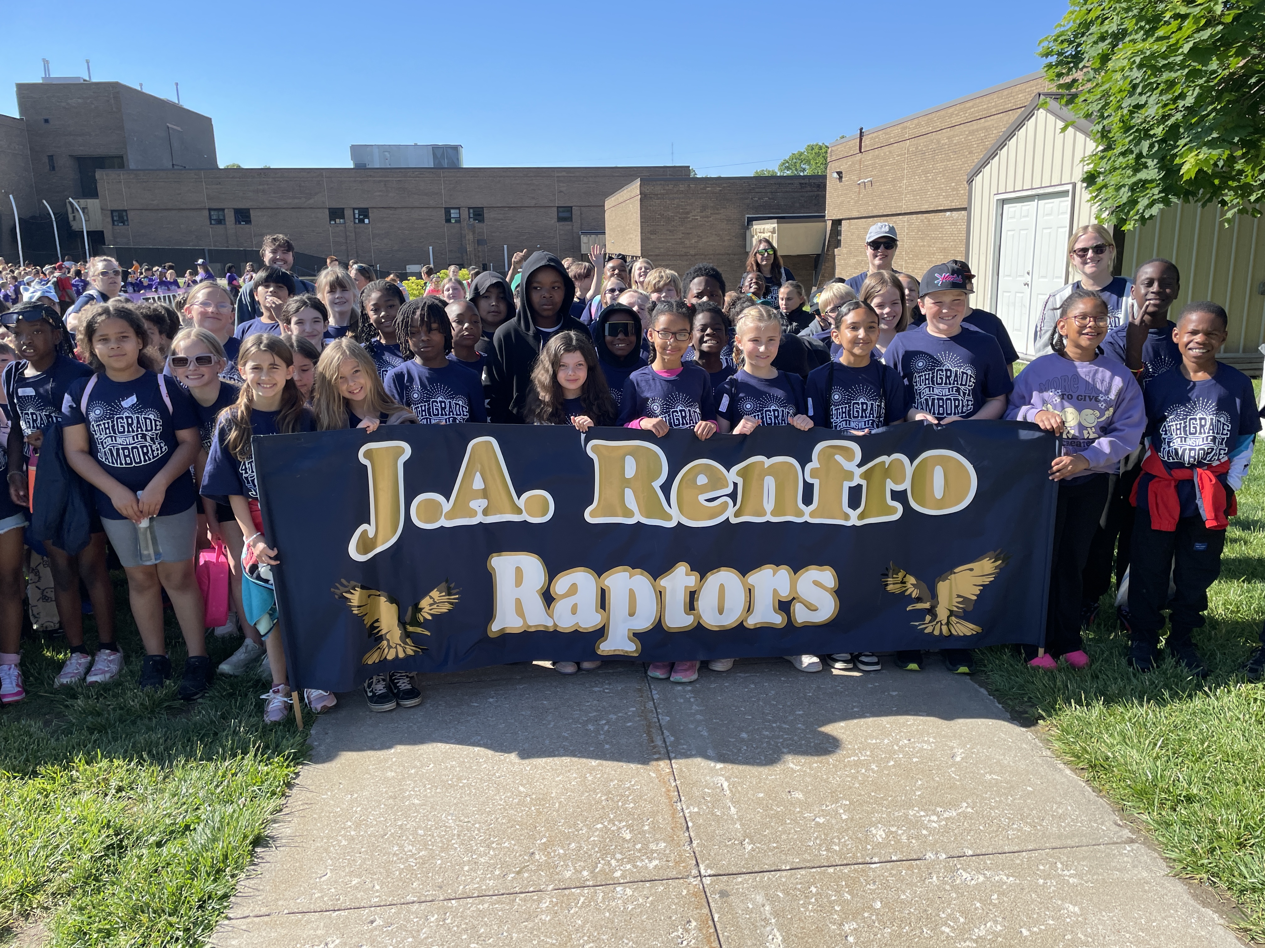 A large group of students and adults pose for a photo holding a banner that reads 'J.A. Renfro Raptors'.