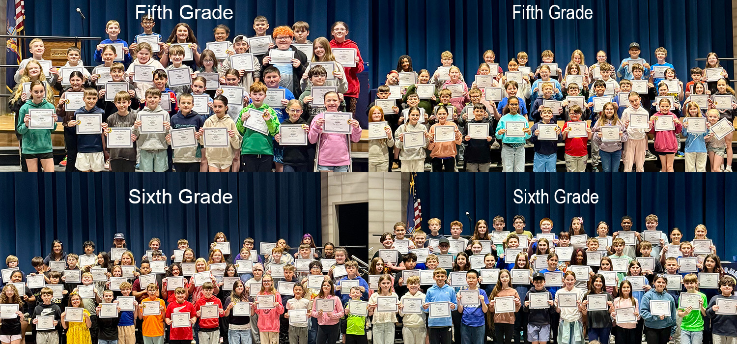 A large group of fifth-grade and sixth-grade students proudly hold certificates on stage.
