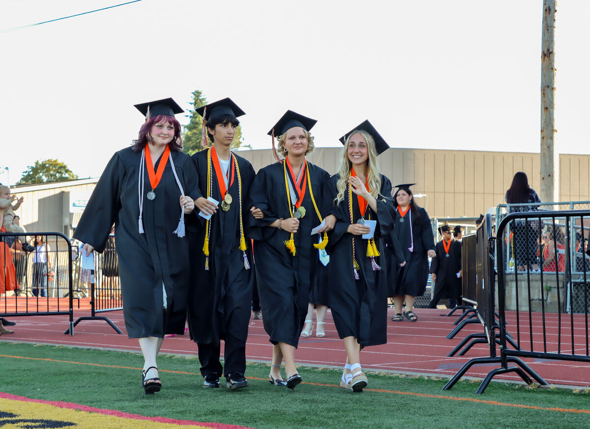 four silverton highschool graduates smile as they enter the ceremony