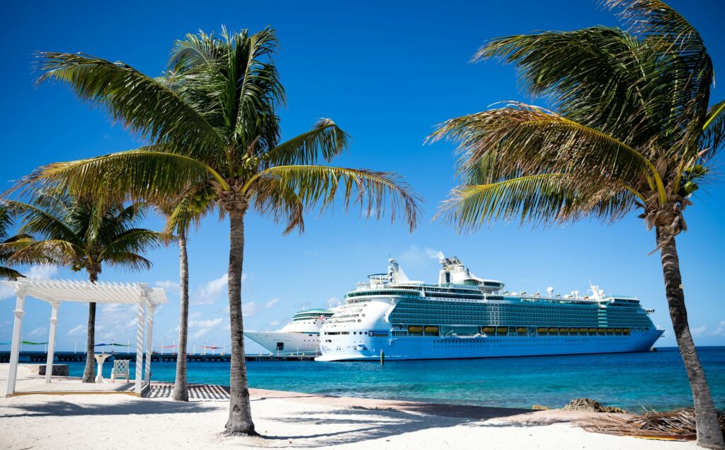 A Caribbean cruise ship in the distance of a sunny boardwalk