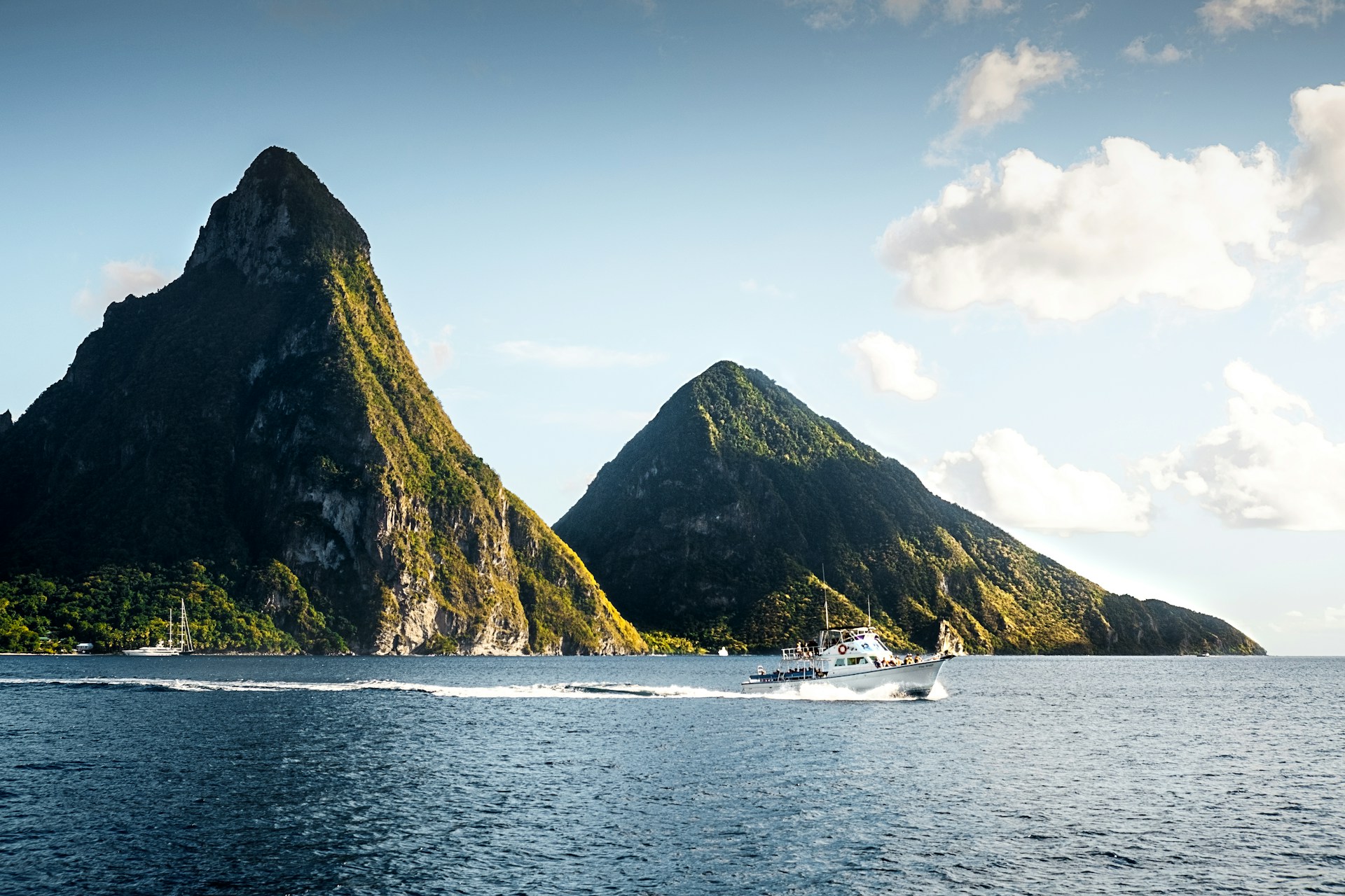 boat passing in front of large rock formations in sea
