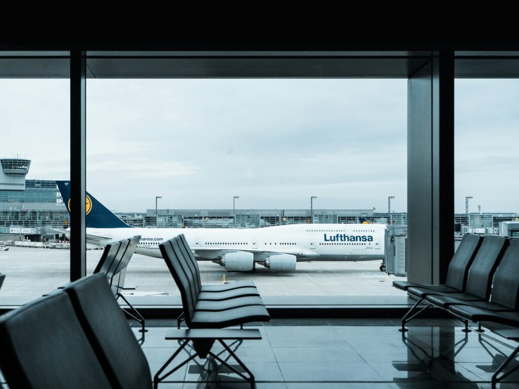 The waiting area of an airport, with a Lufthansa plane in the background