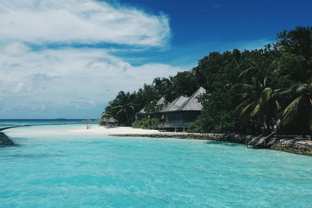 A clear beach with wooden huts in the Maldives