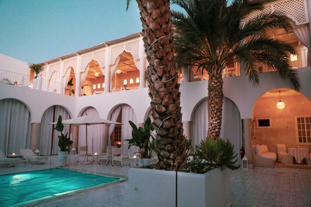 A hotel courtyard with palm trees and a pool in Marrakech
