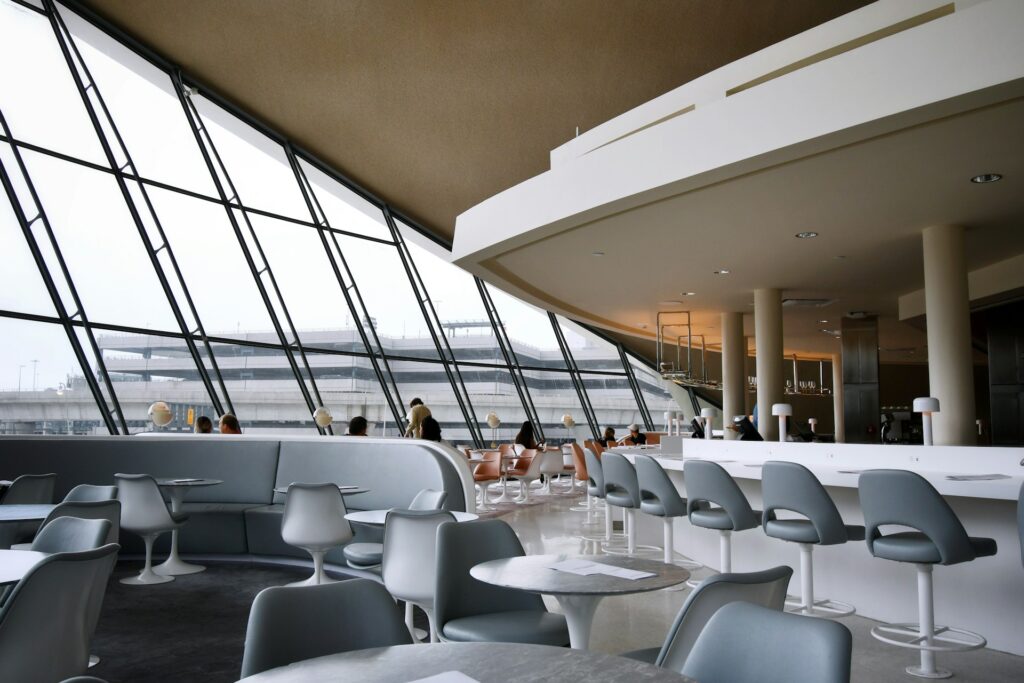 An airport hotel lounge with a bar, large windows and comfortable seating