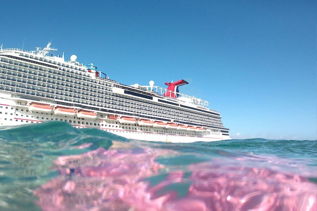A Carnival cruise ship with a coral reef in the foreground